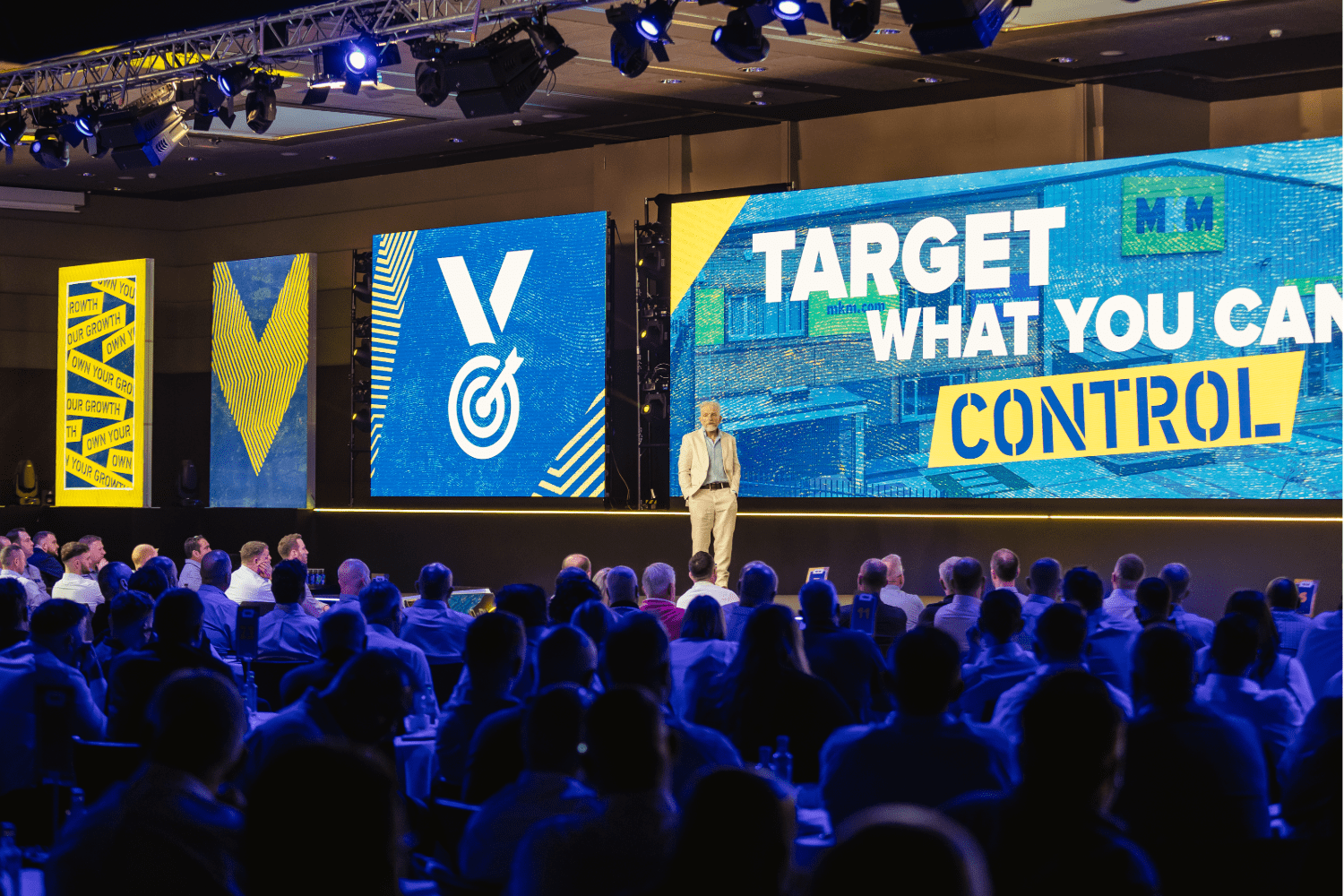 Discover why delegates in 2026 expect more from corporate events and how strategic event planning and management can deliver memorable experiences. Audience looking at an event stage with full AV and production.